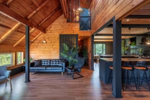 a kitchen and living room with wood ceilings and a bar at Hooting Owl private ski chalet in Niseko