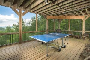 a blue ping pong table on a wooden deck at Cucumber Tree Lodge in Banner Elk