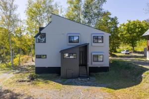a small white house with a garage at Hooting Owl private ski chalet in Niseko