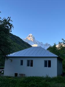 a white house with a mountain in the background at Leo Guesthouse in Dolasvip'i
