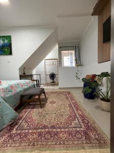a bedroom with a bed and a rug on the floor at Studio 25 Na Cidade do CAFÉ 300m do Centro in Brejetuba