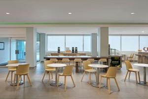 a dining area with tables and chairs in a building at Element by Marriott Arundel Mills BWI Airport in Hanover