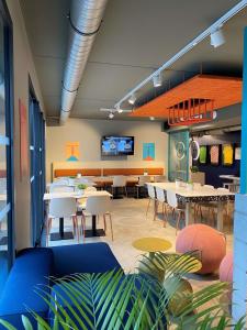 a dining room with tables and chairs and a tv at ibis budget Loudéac Vélodrome in Loudéac