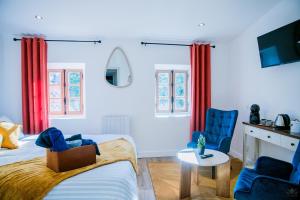 a bedroom with two beds and two blue chairs at Ô Berge De La Cité in Carcassonne