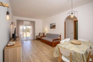 a living room with a table and a bedroom at Renovated Algarve Apartments with Pool in Armação de Pêra