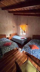 a room with three beds and a window at Jazz House Pucon in Pucón