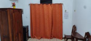 an orange curtain in a room with a table at las cabinas del sueño in Nicoya +10 photos