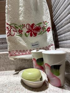 a white bag with a green bowl and two cups at Studio 25 Na Cidade do CAFÉ 300m do Centro in Brejetuba