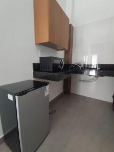 a small kitchen with a counter and a microwave at Lar Doce Lar Realizando Sono suíte1 in Arcos +8 photos