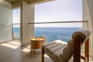 a room with a chair and a large window at Horizon living Madeira in Caniço
