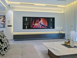 a living room with a couch and a tv on a wall at Elite'Stay by Al Amir in Cabo Negro