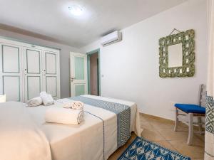 a bedroom with two beds and a mirror on the wall at GioYa House in Pittulongu