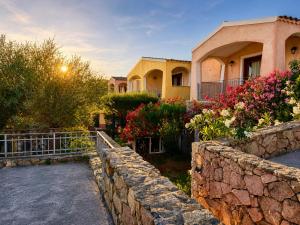 a house with a stone wall and flowers at GioYa House in Pittulongu