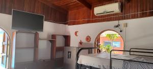 a room with a table and a tv on the wall at las cabinas del sueño in Nicoya