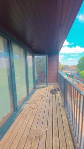 an empty porch with a wooden deck with windows at studio with ensuite in New Bedfont
