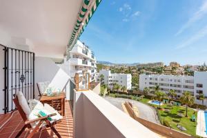 a balcony with chairs and a view of the city at APARTAMENT MIJAS BEACH, ÁNGEL in La Cala de Mijas