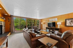 a living room with leather furniture and a large window at Lodgepole #2003 in Keystone