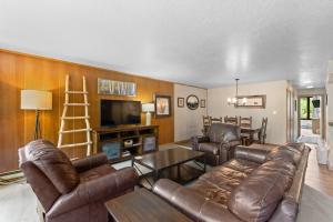 a living room with leather furniture and a flat screen tv at Lodgepole #2003 in Keystone