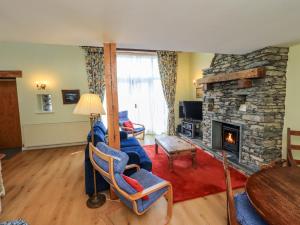 a living room with a couch and a fireplace at Pheasant Cottage in Grange Over Sands