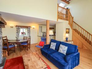 a living room with a blue couch and a table at Pheasant Cottage in Grange Over Sands