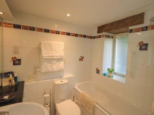 a bathroom with a toilet and a tub and a sink at Pheasant Cottage in Grange Over Sands +34 photos
