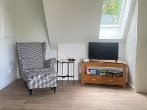ein Wohnzimmer mit Fernseher und Sessel in der Unterkunft Hof Husmann in Extertal