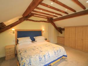 a bedroom with a large bed and wooden ceilings at Pheasant Cottage in Grange Over Sands