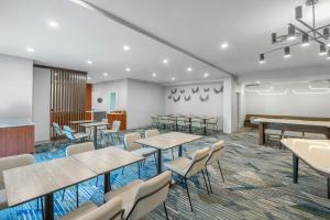 an empty waiting room with tables and chairs at SpringHill Suites by Marriott Atlanta Kennesaw in Kennesaw