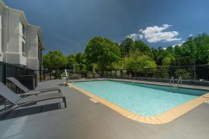 a large swimming pool with chairs at SpringHill Suites by Marriott Atlanta Kennesaw in Kennesaw