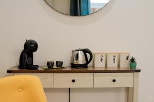 a mirror on top of a table with a tea kettle and books at Ô Berge De La Cité in Carcassonne