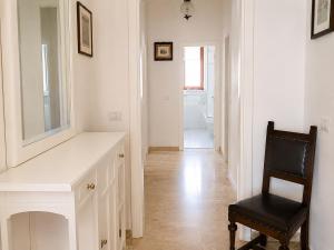 a white hallway with a chair and a mirror at Malù camera doppia in Appartamento - lungomare Crotone in Crotone +9 photos