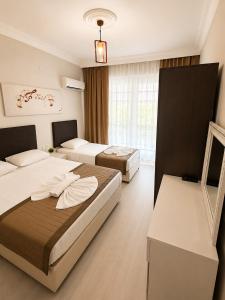 a hotel room with two beds and a window at Giray Butik Hotel in Alanya