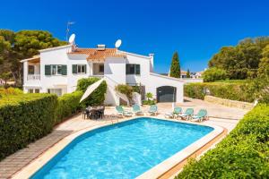 a villa with a swimming pool and a house at Villa Luisa in Cala Galdana