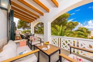 a balcony with tables and chairs and a view of the ocean at Villa Luisa in Cala Galdana