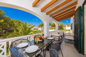 a patio with a table and chairs on a balcony at Villa Luisa in Cala Galdana