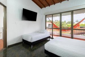 a bedroom with two beds and a flat screen tv at Hotel Chalet La Sofia by Majuva in Armenia