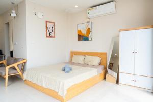 a bedroom with a bed with a teddy bear on it at Nest West Lake - Apartment Hà Nội in Hanoi