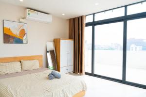 a bedroom with a bed and a large window at Nest West Lake - Apartment Hà Nội in Hanoi +25 photos