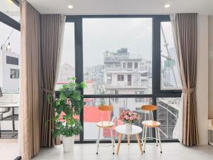a room with a large window with chairs and a table at Nest West Lake - Apartment Hà Nội in Hanoi