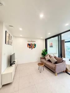 a living room with a couch and a tv at Nest West Lake - Apartment Hà Nội in Hanoi