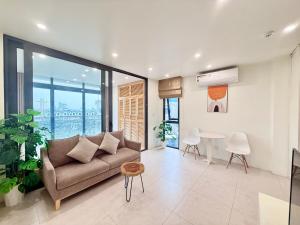 a living room with a couch and a table at Nest West Lake - Apartment Hà Nội in Hanoi