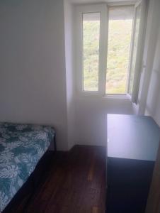 a small room with a bed and two windows at Chez Eli in Luri