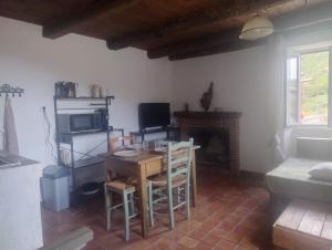 a living room with a table and a fireplace at Chez Eli in Luri