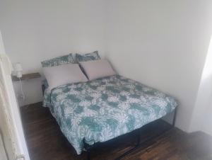 a small bed with a green and white bedspread at Chez Eli in Luri