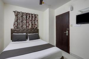 a bedroom with a bed with a brown headboard and a door at Collection O Lotus Grand in Hyderabad +28 photos