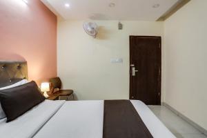 a bedroom with a bed and a door with a fan at Collection O Lotus Grand in Hyderabad