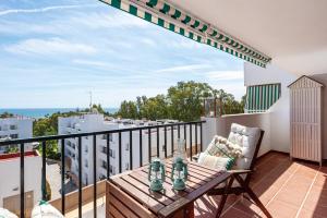 a balcony with a wooden table and a chair at APARTAMENT MIJAS BEACH, ÁNGEL in La Cala de Mijas