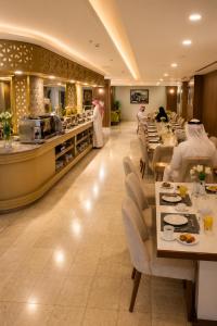 a restaurant with tables and chairs and a buffet at TULIP PLAZA - By Le Park Concord in Hafr Al-Batin