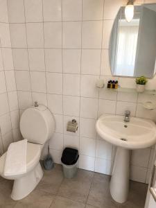 a white bathroom with a toilet and a sink at Giray Hotel in Alanya +53 photos