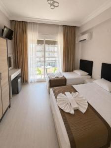 a hotel room with two beds and a television at Giray Hotel in Alanya